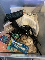 View of toiletry items including brushes, cloths, and a small purse inside a storage container.