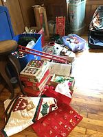 Overview of boxes containing Christmas wrap, ribbons, tissues, and other holiday decor items.