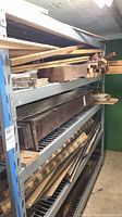 Photo showing the metal rack loaded with wood scraps and other items, highlighting the structure and shelving design.