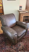 Front angle view showing padded armrests and cushioned seat, brown leather-like upholstery.