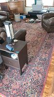 Full view of the rug in a room with furniture and various items on it.