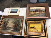 Four old paintings on white table showing various landscapes and farm scenes.