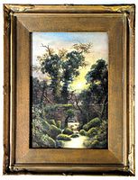 Frontal photo of framed watercolor painting showing detailed landscape with trees, stone bridge, and stream under a glow.