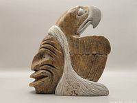 Side view of the stone carving showing the carved eagle profile with detailed wings and white accents.