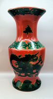 Front view of porcelain vase showing green dragon on red background and flared top.