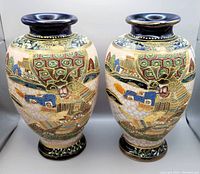 Pair of large Japanese Satsuma style vases with samurai warrior hand paintings, showing front views of both vases side by side.
