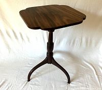 Front perspective view of antique Federal-style tilt-top candle table, showing clover-shaped top, turned column, and tripod legs.
