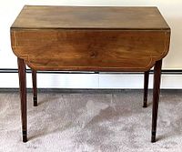 Front view with leaves down showing scalloped leaf ends and slender taper legs