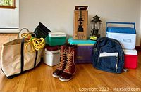 Overall view of all items included in the lot: boots, bags, coolers, and camping lantern