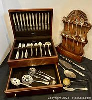 Drawer section of box with grouped forks, spoons, and knives handles up