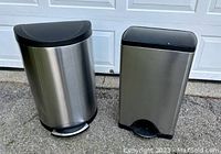 Two SimpleHuman stainless steel step trash cans, one cylindrical with rounded top and one rectangular, shown side by side.