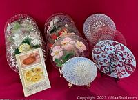 Photo showing full collection of colorful Sydenstricker glass plates arranged grouped, displaying various floral and geometric patterns front and back.