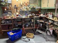 Wide shot of workbench area showing assorted tools, toolboxes, bins and saw horse