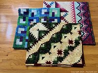 All three quilts overlapped on hardwood floor