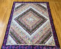 Full view of quilt laid flat on floor showing overall pattern and border