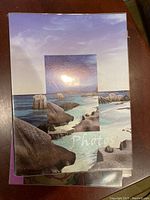 Close-up photo of photo album cover featuring a beach scene with rocks, water, and sky, with the word 'Photo' partially visible.