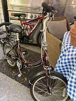 Left side view of maroon Schwinn folding bicycle with fenders and rear rack