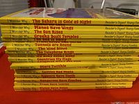 Stacked 25 yellow spine vintage books from Reader's Digest "I Wonder Why" series showing titles and condition.