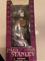Front view of Paul Stanley figurine packaged in original box with KISS branding and star motifs.