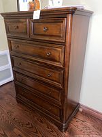 Front and side view showing overall shape, finish, and six drawers