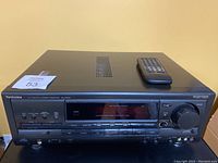 Front view of the Technics SA-EX600 AV Control Stereo Receiver with remote control placed on top.