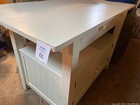 Closed tabletop and storage base showing white painted finish and cabinet doors under counter top