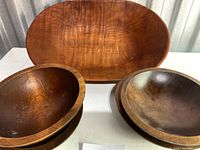 Five wooden bowls displayed: one large shallow oval Baribocraft salad bowl at back, four smaller round wooden bowls grouped in front.