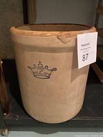 Full front view of large 2 gallon crock showing body shape, natural beige stoneware color and blue crown with number 2 decoration.