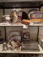 Metal baking pans, rolling pin, cookie tins, and miscellaneous baking items on metal shelves.