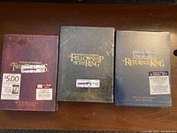 Photo showing all three unopened Lord of the Rings DVD sets: The Two Towers, The Fellowship of the Ring, and The Return of the King, arranged side by side.