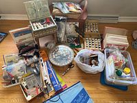 Overall view of sewing accessories lot including basket, thread cases, scissors, plastic containers with notions