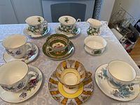 Photo showing nine assorted fine bone china teacups with matching saucers, various floral and decorative patterns