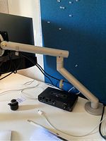 Monitor arm and Dell display installed on desk, showing arm articulation and cable routing