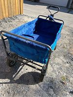 Front angle of the blue folding wagon/cart showing fabric sides, metal frame, and four wheels.