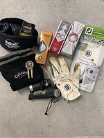 Full view of golf accessories including gloves, balls, glasses, range finder, tees, and pouch.