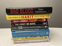 Stack of 8 leadership, coaching, and business books showing spines and titles.