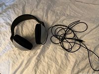 Over-ear silver and black Sony stereo headphones lying flat with long cord exposed.