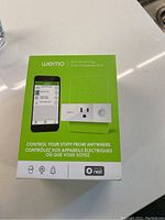 Front view of the Wemo Wi-Fi Smart Plug box featuring product image, smartphone app interface, and Nest compatibility logo.