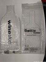 Two transparent bubble wrap wine bags shaped for bottles with protective air bubbles. One labeled 'wineskin', the other 'Bottle bubble XL'.