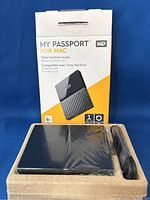 My Passport for Mac external hard drive in original box with packaging and device wrapped in plastic, with USB 3.0 cable included.