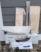 Complete view of the boat hull with packaged wooden planks and instruction manual on box