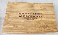 Wooden box labeled for linoleum block cutting and wood carving tools.