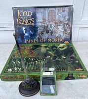 Overview of two boxed sets, blister pack miniature, and sword letter opener on display
