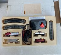 Full view of boxed N scale model train set including power source, train cars, and tracks in original fitted plastic packaging.