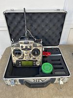 Futaba T9CHP CAMpac transmitter in foam-padded metal carrying case with spare battery and compartments for parts.