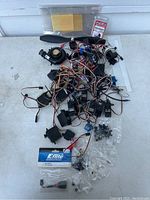 Photo showing assorted RC small engine parts including servos, wiring, propeller, and connectors.