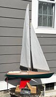 Overall view of Robbe Comtesse remote control sailboat on wooden stand showing sails and hull.