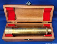 Brass telescope inside open wooden box with red felt lining, engraved with comet and inscription for 1985-1986 Halley's Comet.