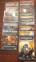 Top view of all 14 Warhammer books laid out showing front covers with titles and artwork.