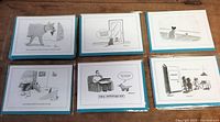 Six New Yorker cat-themed cartoon cards laid out in two rows of three each, showing various cartoon scenes including a cat holding a doll, a cat looking in the mirror, among others.